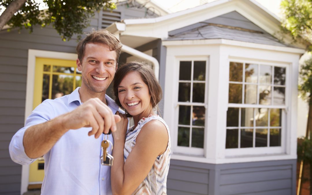 man and woman happy in front of their home